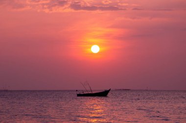 Gün batımında balıkçı gemisinin silueti