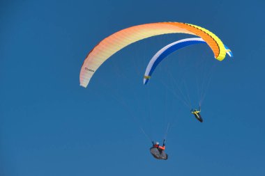 Paragliding chase in the blue sky clipart