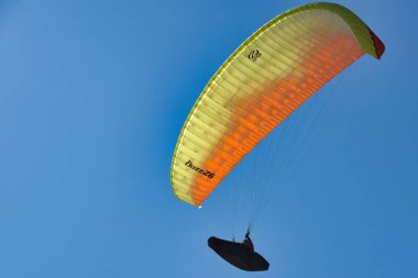 # Mavi gökyüzünde süzülen bir paraglider #