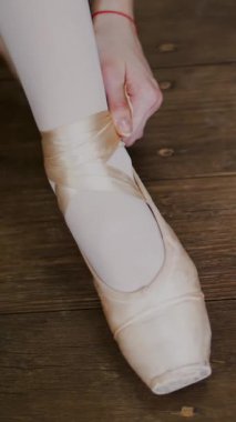 yakın, balerinler ayakkabı değiştirmek içine özel bale ayakkabıları, pointe ayakkabı, dantel bale sınıf eski bir ahşap zemin üzerinde bale şeritler..