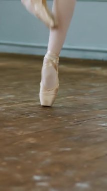 yakın, dans salonunda balerin gerçekleştirmek ssissonne basit, pointe ayakkabı ayak zarif, bale sınıf eski bir ahşap zemin üzerinde duruyor..