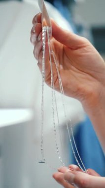 Mücevherler dükkanda. Ivır zıvır. Yakın plan. Bir alışveriş merkezinden mücevher almak. Bir kadın satın almadan önce zinciri inceler..