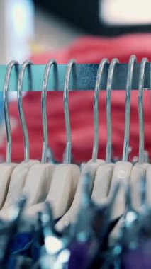 Elbise askıları. Yakın plan. Birçok elbise askısı mağazadaki metal raflarda asılı. Alışveriş merkezinden kıyafet almak. Satış ve alışveriş. Moda butiği. giyim mağazası.