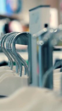 Elbise askıları. Yakın plan. Birçok elbise askısı mağazadaki metal raflarda asılı. Alışveriş merkezinden kıyafet almak. Satış ve alışveriş. Moda butiği. giyim mağazası.
