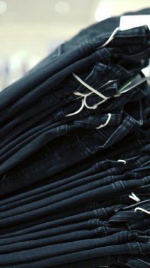 Mağazadaki bir rafta kot pantolon. Yakın plan. Yeni kot pantolon, kot pantolon bir giyim mağazasının raflarında duruyor. Farklı boylarda ve tarzlarda kot pantolon. çeşitli kot modelleri.
