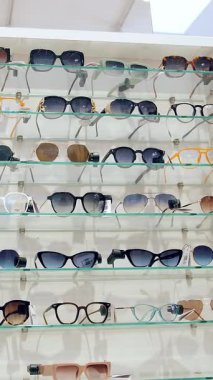 Güneş gözlüğü. Moda gözlüklerinin farklı modelleri olan bir vitrin. Perakende alışveriş merkezi. Gözlük. Alışveriş. Dükkandan güneş gözlüğü almak, süpermarket. Optik dükkanı...