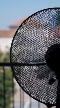 Elektrik vantilatörü. Elektrikli havalandırma. Yakın plan. Odada çalışan bir vantilatörün siyah silueti, pencerenin karşısında. Odayı soğutuyorum...