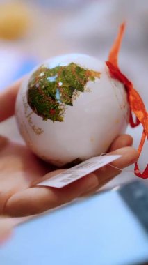 Cep telefonunu kullan. Noel süsleri. Alışveriş. Yakın plan. Müşteri akıllı telefonuyla yazarken, hediye seçerken, bir mağazadaki festival aksesuarları, adil, süpermarket ya da Noel öncesi alışveriş merkezlerinde. İyi tatiller. Noel Ruhu.