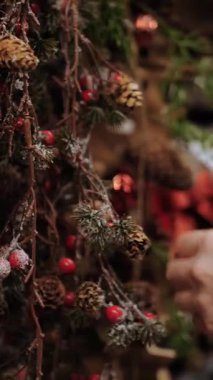 Noel alışverişi, dekorasyon, fuar. Yakın plan. Kadın dükkanda Noel için aksesuar seçiyor. Noel için süsleme olarak, kozalaklı bitkilerin yapay dalları.