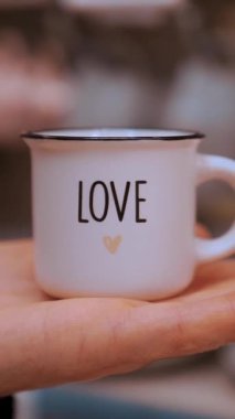 Sevgililer Günü. Yakın plan. Küçük kahve fincanı, avuç içine aşk yazma. Sevgililer gününde hediye, duyguların ve sevginin ifadesi olarak. Aşk konsepti.