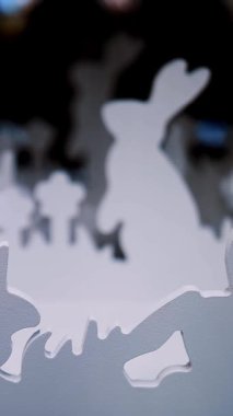 Paskalya panayırı. Yakın plan. Çimlerin üzerinde kontrplaktan yapılmış Paskalya tavşanlarının dekoratif beyaz heykelcikleri bir mağazada sergileniyor. Geleneksel Avrupa paskalya dekoru ve dekorasyonları.