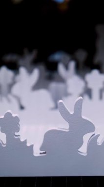 Paskalya panayırı. Yakın plan. Çimlerin üzerinde kontrplaktan yapılmış Paskalya tavşanlarının dekoratif beyaz heykelcikleri bir mağazada sergileniyor. Geleneksel Avrupa paskalya dekoru ve dekorasyonları.