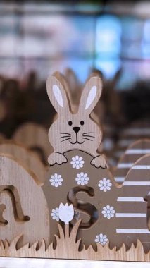 Paskalya indirimi. Paskalya süslemeleri ve dükkandaki ev için hediyeler. Ahşap, kontrplak ve geleneksel Paskalya tavşanları ve yumurtalarından oyulmuş dekoratif Paskalya Paskalyası bir mağazada sergileniyor..