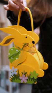 Paskalya panayırı. Yakın plan. Süslü Paskalya hediyeleri, kadın ellerinde tavşan çantaları. Paskalya alışverişi süpermarkette ya da markette. Geleneksel Avrupa paskalya dekoru ve dekorasyonları.