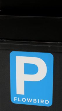 Akan Kuş 'tan güneş enerjisiyle çalışan bir parkmetreye yakın plan üzerinde şehir yaşamı unsurları, çevre dostu kentsel ulaşım çözümleri