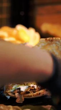 Şef şu malzemeleri kullanarak shawarma hazırlıyor: lavaş, et, sos, sebze, salatalık, soğan, lahana, baharatlı biber, patates, yeşillik, havuç