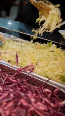 Şef şu malzemeleri kullanarak shawarma hazırlıyor: lavaş, et, sos, sebze, salatalık, soğan, lahana, baharatlı biber, patates, yeşillik, havuç