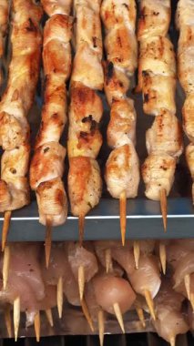 Şişte kızarmış et. Şiş kebap ya da şiş kebap. Yakın plan. Izgara sulu domuz etiyle pişirilmiş. Küçük kebaplar, ahşap şişler üzerinde et parçaları, ateşte kızartılmış..