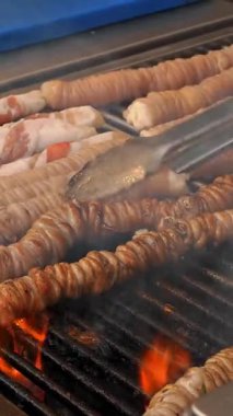 Şişte kızarmış et. Şiş kebap ya da şiş kebap. Yakın plan. Izgara sulu domuz eti ve tavuk etiyle pişirilmiş. Küçük kebaplar, ahşap şişler üzerinde et parçaları, ateşte kızartılmış..