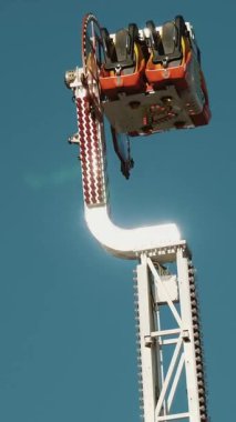 Popüler salıncaklar. Atlıkarınca. Dönen sarkacı sürüyorum. Tema temelli eğlence parkı. Yumuşak güneş ışığı.