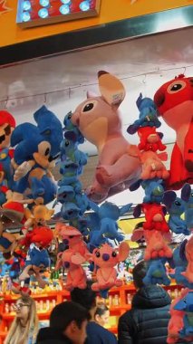 BIELLA, İtalya, 11 Haziran 2022: oyuncuları ayartmak için bir sürü sevimli oyuncakla dolu bir panayır tezgahı. Lunaparkın Gece Işıkları. Gece Eğlence Fuarı. Parlayan ışık.