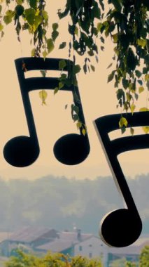 Düğün dekoru. Çok renkli kurdelelerde ağaçtan sarkan müzikal dekoratif notalar.