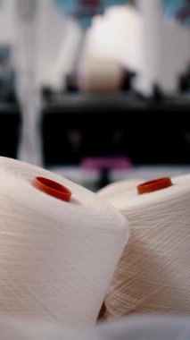 İplik ipliklerinin yakın çekim makaraları. Dönen yapım. Tekstil fabrikası. İplik yapma süreci. İplik üretimi. Tekstil fabrikası ekipmanı. Makaraları geri sarmak ya da pamuklu ya da yün ipliklerle bobinleri sarmak.