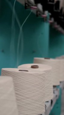 İplik yapma süreci. İplik üretimi. Tekstil fabrikası ekipmanı. Tekstil fabrikası. Dönen yapım. Makaraları geri sarmak ya da pamuklu ya da yün ipliklerle bobinleri sarmak. İplik ipliklerinin yakın çekim makaraları.