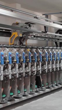 Tekstil fabrikası ekipmanı. Tekstil fabrikası. Dönen yapım. İplik yapma süreci. İplik üretimi. Fabrika makineleri makaraları ya da pamuklu ya da yün ipliklerle bobinleri geri sarıyor.