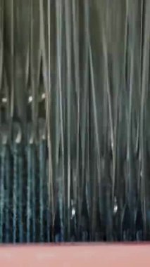 Tekstil fabrikası. Dokuma. Çalışan otomatikleştirilmiş dokuma makinelerinin yakın çekim görüntüleri. Tekstil fabrikası ekipmanı. Dokuma kumaşı endüstriyel bir makine tarafından serbest bırakılıyor..