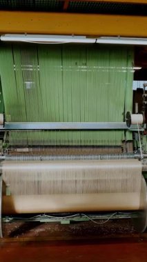 Dokuma tezgahı. Dokuma fabrikası. Tekstil endüstrisi. Otomatik dokuma makinesi iplik kumaşı üretiyor. Tekstil fabrikası ekipmanı. kumaş üretimi.