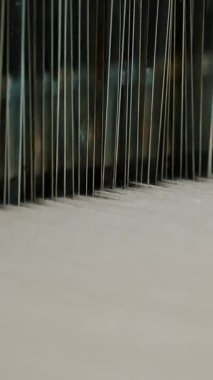 Tekstil fabrikası. Dokuma. Çalışan otomatikleştirilmiş dokuma makinelerinin yakın çekim görüntüleri. Tekstil fabrikası ekipmanı. Dokuma kumaşı endüstriyel bir makine tarafından serbest bırakılıyor..