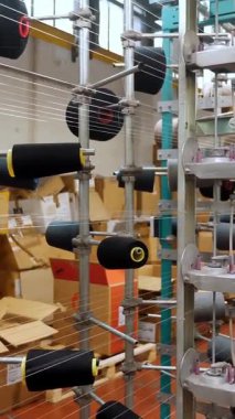 İplik makaraları. Tekstil endüstrisi. Dokuma fabrikası. Bir sürü iplik makarası olan raflar. Daha fazla kumaş üretimi için ipliklerin boyanıp kurutulması. Otomatik çalışma süreci. tekstil üretimi.