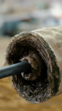 Roll of fabric. close-up. sewing. tailor unrolls a roll of camouflage fabric on sewing table in sewing workshop. khaki, dark green fabric. sewing of camouflage military clothes.