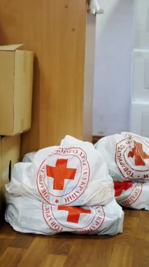 Kızıl Haç. Hayır kurumu. Gönüllü Depo. İnsani yardım paketleri, kırmızı haç amblemli karton kutular. Yoksul insanlar için sosyal bağışlar