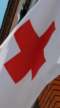 Kızıl haç amblemli beyaz bayrak. Yakın plan. Kızıl Haç. Uluslararası hayır kurumu fakir insanlara insani yardım ve sosyal bağışta bulunuyor