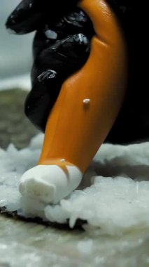 Suşi. Japon yemeği. Yemek pişirmek. Mutfak. Suşi şefi bambu hasırı kullanarak suşi yapıyor. Krem peynirli suşi, salatalık malzemeleri, pirinç, yosun. Yakın plan. Restoranın mutfağında.