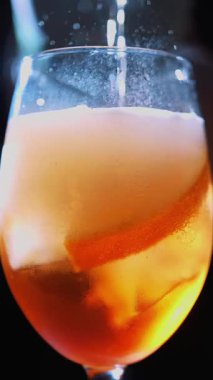 Cocktail. making a cocktail. bartender makes cocktail. close-up. Bartender gently pours a drink into a wine glass with ice on bar counter. muffled light background.