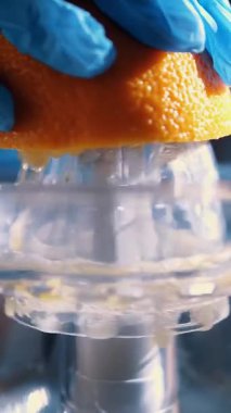 Turuncu taze. Meyve sıkacağı. Portakal suyu yapıyorum. Turunçgil suyu. Yakın plan. Eldivenli bir el portakaldan meyve suyu sıkıyor..