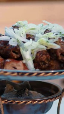 Lula kebabı. Yemek pişirmek. Şişte et. Izgarada et var. Yakın plan. Lokantada taze ızgara lula kebabı ve doğranmış soğan servis ediliyor. Gürcistan mutfağı.