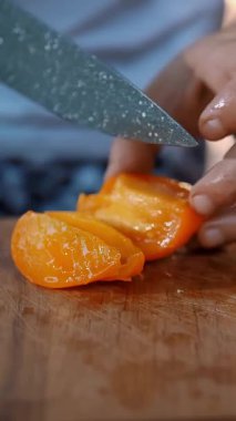 Domates. Taze sebze doğramak. Dilimlenmiş domates. Salata. Yemek pişirmek. Yakın plan. Şef taze sarı domatesi bıçakla kesiyor salata için, tahta tahtada..