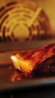 Kızarmış et. Yakın plan. Bir parça et fırında kavruluyor. Pişirme tepsisinde soslu bir kaburga. Bir restoranda yemek yapmak..