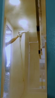 Sprey boya. Yapım atölyesinde resim yapmak. Endüstriyel fabrikada çelik yapının üstüne sprey tabancayla boya..