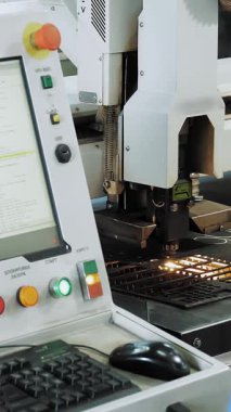 Laser metal cutting. close-up. operator supervises operation of laser cutting machine for sheet metal sitting in front of a monitor, computer. laser is cutting patterns on sheet metal plate.