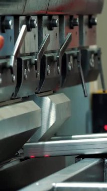 Metal bükme. Yakın plan. Fabrikadaki hidrolik bir makinede metal bükme levhası. Metal işleme makinesi. Metalurji endüstrisi.