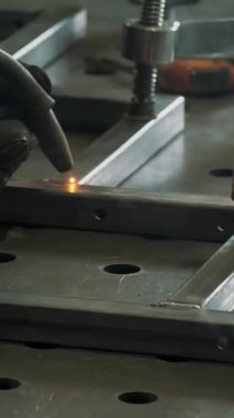 Welding. welding of metal products. close-up. A man in a mask welds metal construction in workshop, at the enterprise. sparks fly to the sides.