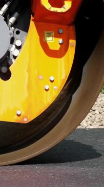 yakın çekim, yol yapımı silindir kompaktör makine, asfalt finisher ile çalışır. Taze asfalt kaplama üzerine çakıl yol yapımı sırasında temel döşeme yol silindiri