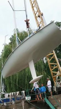 Kiev, Ukrayna, Yatçılık-Temmuz 29, 2018: Dinyeper Nehri kıyısında pier, üzerine beyaz bir yat Yükaldırma vinç yükseltir. yere otopark özel sabitleme koymak.