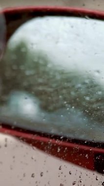 yakın çekim, damla su araba sürüş sırasında yan pencere. Güçlü rüzgar damlacıkları cam aşağı değil, ama yukarı doğru akar. pencereden yan dikiz aynası görebilirsiniz