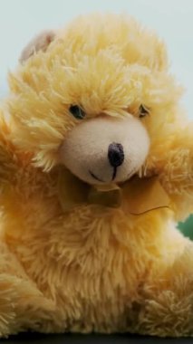 Yakın plan, ön camın önünde duran bir oyuncak ayı resmi. Yağmur, araba silecekleri, arabanın içindeki silecekler, cam sileceği yağmuru.